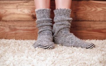 young woman with heavy socks standing on fuzzy carpet over cold floor