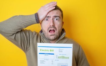 man with high energy bill holding his head in disbelief