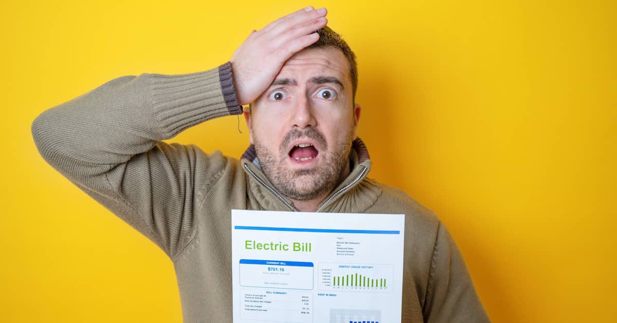 man with high energy bill holding his head in disbelief