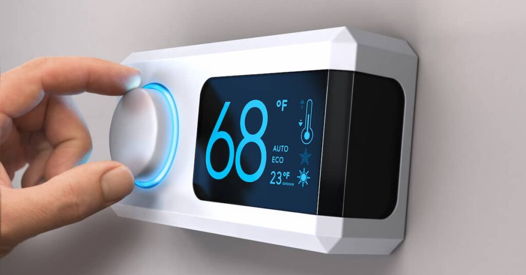 Person saving energy fro summer by setting programmable thermostat for 68 degrees | REenergizeCO